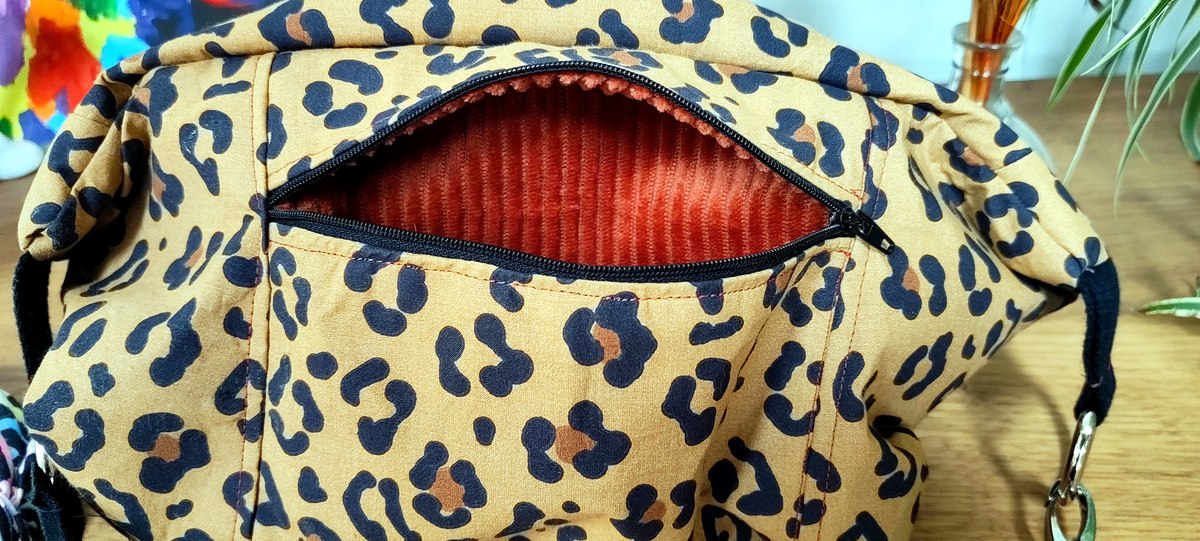 Détail cousu à la main d'un sac banane FermeLa, tissu léopard, gros plan sur la couture